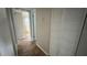 Bright hallway with wood-look tile floors, linen closet, and bedroom access at 9612 Valencia Cv, Bradenton, FL 34210