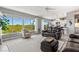 Open living area showcasing leather sofas, a large TV and access to a balcony at 4013 Catalina Dr # 4013, Bradenton, FL 34210