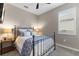 Cozy bedroom with metal bed frame, blue bedding, and a window with plantation shutters at 16215 Tradewind Ter, Lakewood Ranch, FL 34211