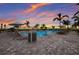 Resort-style pool with lounge chairs and umbrellas at sunset at 16215 Tradewind Ter, Lakewood Ranch, FL 34211