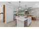 Open concept kitchen with white cabinets, large island, and views to the living room and backyard at 16215 Tradewind Ter, Lakewood Ranch, FL 34211