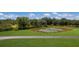 Property with pond, lush landscape, and a long driveway at 7301 221St E St, Bradenton, FL 34211