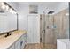 Bathroom with a walk-in shower, double vanity, and stylish light fixtures at 7301 221St E St, Bradenton, FL 34211