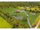 Aerial view of house, pond, and surrounding landscape at 7301 221St E St, Bradenton, FL 34211