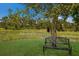 Relaxing backyard with a bench under a tree near a pond at 7301 221St E St, Bradenton, FL 34211