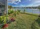 Landscaped backyard with a white fence and lake view, as well as a screened-in pool at 7209 49Th E Pl, Palmetto, FL 34221