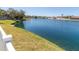 Expansive lake view framed by a white fence and green lawn, showcasing serene community living at 7209 49Th E Pl, Palmetto, FL 34221