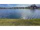 Open lake view, edged by well-kept lawn, under a partly sunny sky, shows lovely community at 7209 49Th E Pl, Palmetto, FL 34221