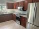 Well-lit kitchen features stainless steel appliances, granite countertops, and abundant wooden cabinets at 7861 Pine Trace Dr # 7861, Sarasota, FL 34243