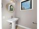 Small bathroom with pedestal sink and round mirror at 8030 Midnight Pass Rd, Sarasota, FL 34242