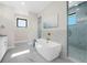 Elegant bathroom with soaking tub, walk-in shower, and marble tile at 8030 Midnight Pass Rd, Sarasota, FL 34242
