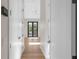 Light-filled hallway with doors to bedrooms and balcony at 8030 Midnight Pass Rd, Sarasota, FL 34242