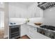 White kitchen with built-in wine fridge and ample storage at 8030 Midnight Pass Rd, Sarasota, FL 34242