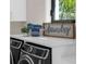 Close-up view of a modern laundry room with stacked washer and dryer at 8030 Midnight Pass Rd, Sarasota, FL 34242