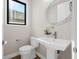 Modern powder room with pedestal sink, toilet, and decorative mirror at 8030 Midnight Pass Rd, Sarasota, FL 34242
