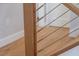 Close-up of modern wood and cable railing detail on a staircase at 8030 Midnight Pass Rd, Sarasota, FL 34242