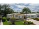 Yellow single-wide mobile home with carport and landscaping at 8454 Imperial Cir, Palmetto, FL 34221