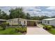 Yellow single-wide mobile home with carport and landscaping at 8454 Imperial Cir, Palmetto, FL 34221