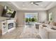 Living room with fireplace, large sectional sofa, and sliding doors to the pool at 2783 Butterfly Jasmine Trl, Sarasota, FL 34240