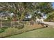 View of the house from the side, showcasing a large tree and a beige fence at 6462 Beechwood Ave, Sarasota, FL 34231