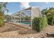 Screened-in pool with stone patio and landscaping at 6462 Beechwood Ave, Sarasota, FL 34231