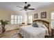 Bright bedroom with a king-size bed, wood flooring, and plantation shutters at 4808 Charles Partin Dr, Parrish, FL 34219