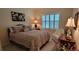 Cozy bedroom featuring a queen-size bed and plantation shutters at 4808 Charles Partin Dr, Parrish, FL 34219