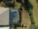 Aerial view of a screened pool with brick pavers and tropical plants at 1362 Hedgewood Cir, North Port, FL 34288