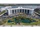 Aerial view of a condo building with parking, landscaping, and a scenic pond at 5855 Midnight Pass Rd # 319, Sarasota, FL 34242
