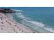 An elevated beach view presents many beachgoers enjoying the ocean and white sand under a partly cloudy sky at 5855 Midnight Pass Rd # 319, Sarasota, FL 34242