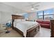 Bedroom featuring a king bed, mirrored wall, a ceiling fan, and a window with treetop views at 5855 Midnight Pass Rd # 319, Sarasota, FL 34242