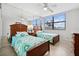 Bright bedroom with twin beds, tiled floors, ceiling fan, a mirrored closet and a large window at 5855 Midnight Pass Rd # 319, Sarasota, FL 34242