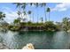 Picturesque pond with a charming waterfall feature, surrounded by lush tropical landscaping and palm trees at 5855 Midnight Pass Rd # 319, Sarasota, FL 34242