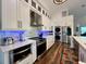 Modern kitchen with white cabinets, stainless steel appliances and a quartz island at 1362 Hedgewood Cir, North Port, FL 34288