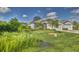 Single-Gathering home with two-car garage, lush landscaping, and a pond at 1362 Hedgewood Cir, North Port, FL 34288