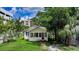 Charming yellow house with a front porch, surrounded by lush greenery at 1569 7Th St, Sarasota, FL 34236