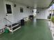 Covered patio with green flooring and steps leading to the entrance at 5530 Denmark Dr, Bradenton, FL 34207