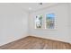 Bright bedroom featuring wood floors, two windows, and neutral paint at 1625 Compass Pointe Ct # 105, Punta Gorda, FL 33950