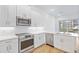 Contemporary kitchen with stainless steel appliances, white cabinets, white countertops, and a view to the balcony at 1625 Compass Pointe Ct # 105, Punta Gorda, FL 33950