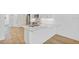 Modern kitchen island featuring white countertop, stainless steel sink, and a view to the living room and stairwell at 1625 Compass Pointe Ct # 105, Punta Gorda, FL 33950
