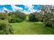 Expansive backyard with mature trees and lush green grass at 3342 Founders Club Dr, Sarasota, FL 34240