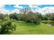 Lush backyard featuring a mature tree with Spanish moss and a pond on the right at 3342 Founders Club Dr, Sarasota, FL 34240