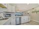 Bright kitchen boasts white cabinets, quartz counters, and stainless steel appliances at 4380 Exeter Dr # 303, Longboat Key, FL 34228