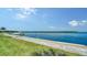 Peaceful waterfront view with grassy area and dock at 4380 Exeter Dr # 303, Longboat Key, FL 34228