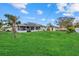 Spacious backyard featuring lush green lawn, mature trees, and a screened-in porch at 5819 2Nd Avenue Nw Dr, Bradenton, FL 34209