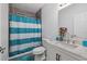 Bright bathroom featuring a shower-tub combo with blue-and-white striped curtain and a modern vanity with marble countertop at 5819 2Nd Avenue Nw Dr, Bradenton, FL 34209