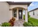 Covered entryway with a blue front door and decorative plants at 8705 Ocean Tides Cv, Parrish, FL 34219