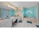 Bathroom with a teal vanity, a large soaking tub, and decorative window at 5819 2Nd Avenue Nw Dr, Bradenton, FL 34209
