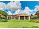 Back exterior of house with covered patio, fenced yard and lush landscaping at 3342 Founders Club Dr, Sarasota, FL 34240