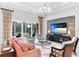 Bright living room with coral sofa, two armchairs, and a large flat-screen TV at 3342 Founders Club Dr, Sarasota, FL 34240
